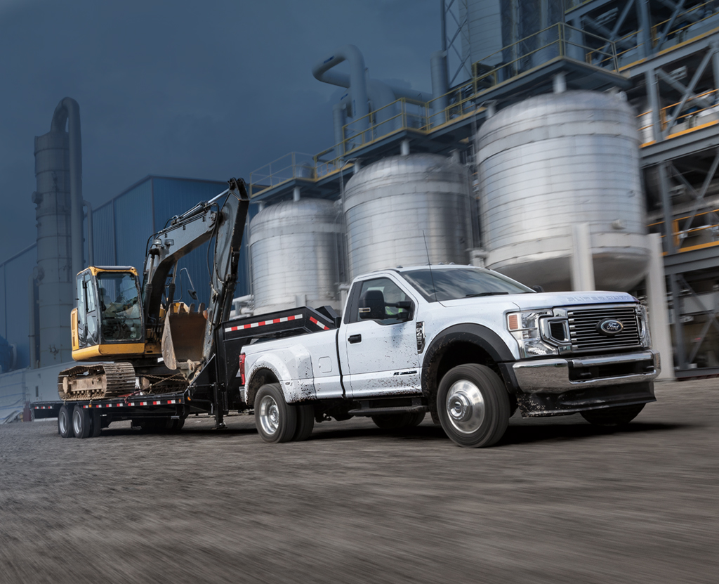 Two workers load fence coils onto a Ford truck.