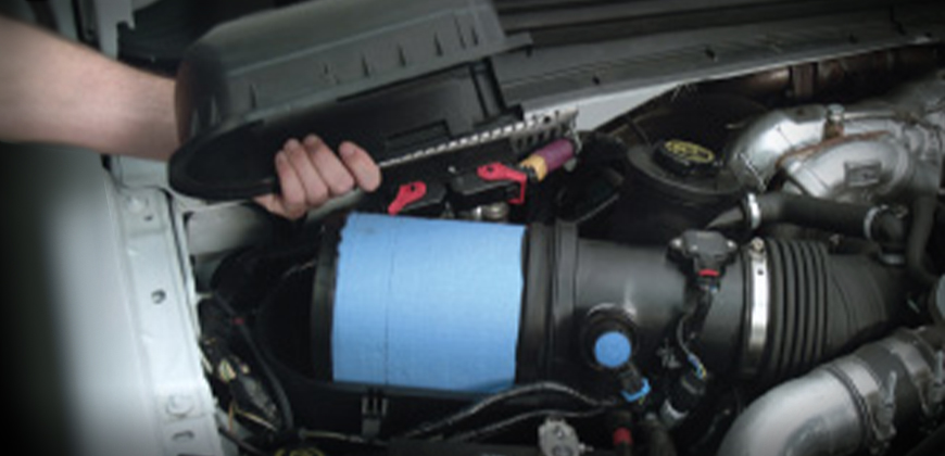 A mechanic installing an air filter in a Power Stroke Diesel engine.