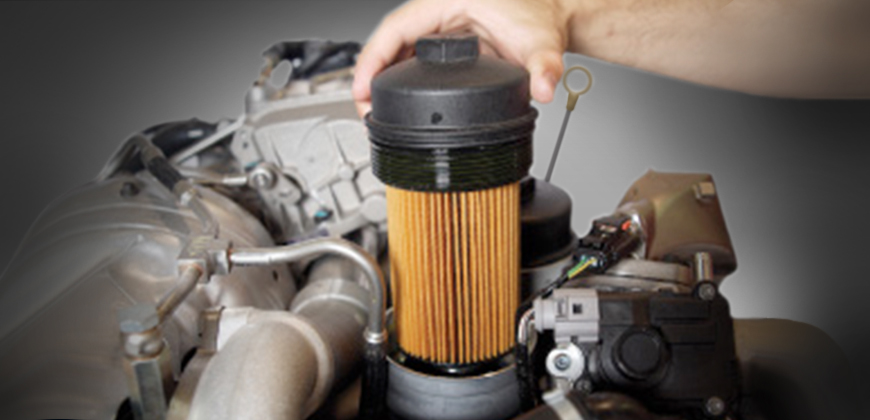 A mechanic installing an oil filter in a Power Stroke Diesel engine.