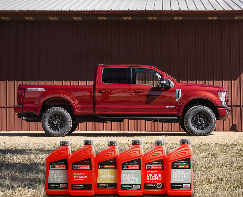 A Ford Super Duty is parked by a barn, and a collection of bottles of oil are shown in the foreground.