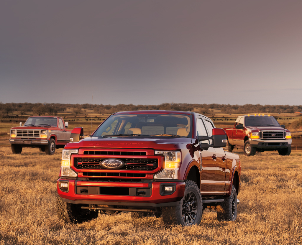 Three legendary Powerstroke Diesel Engine Ford Truck stand proudly in a field.